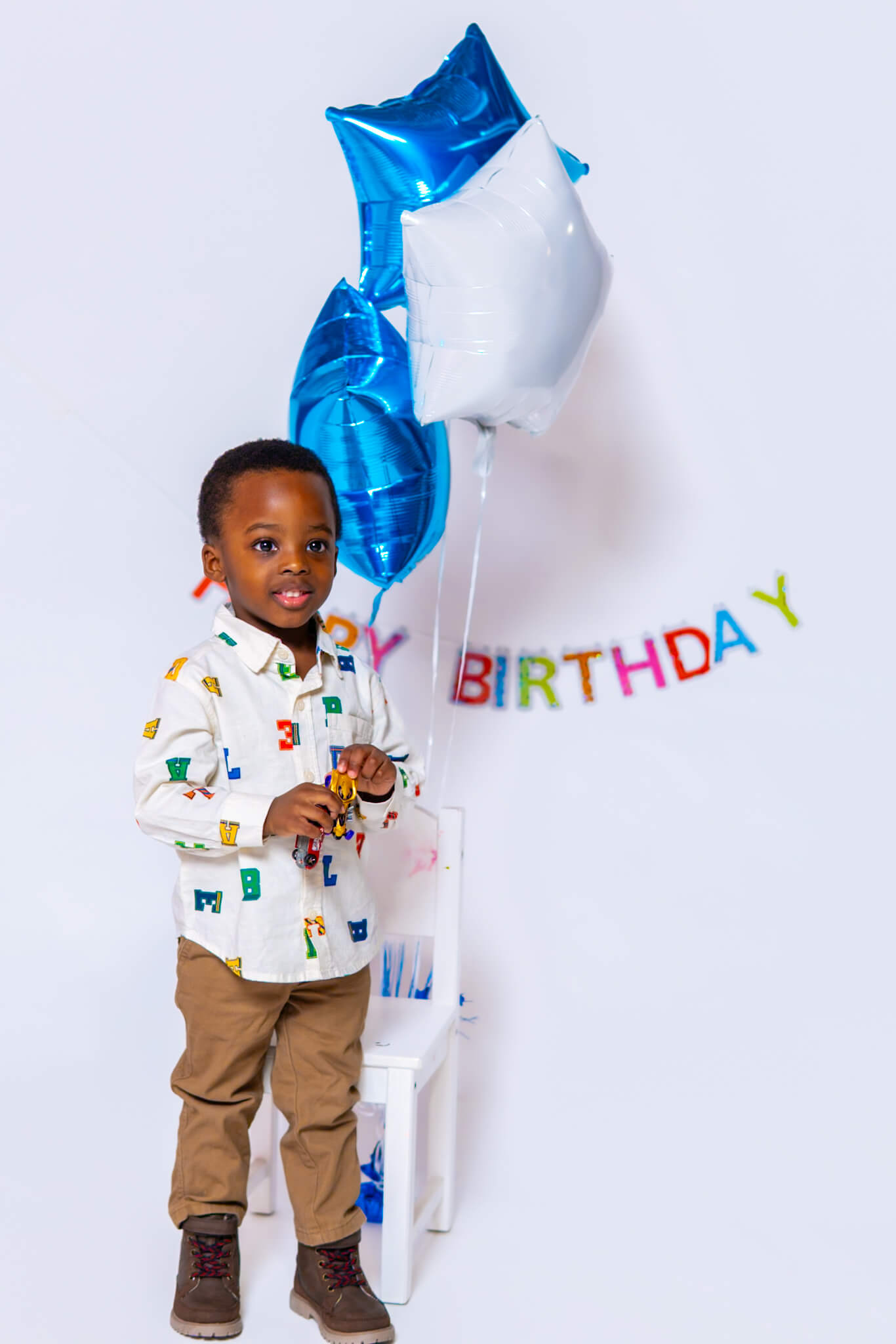 3 year old boy standing in front of birthday balloons in Kitchener studio