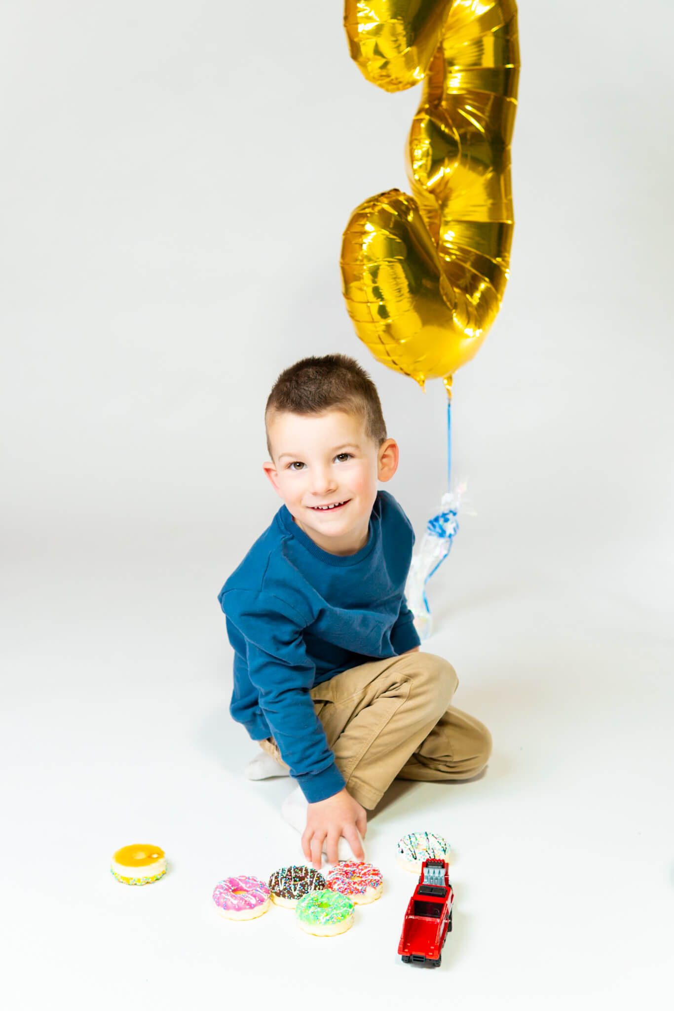 Toddler birthday photo playing with balloon in Kitchener