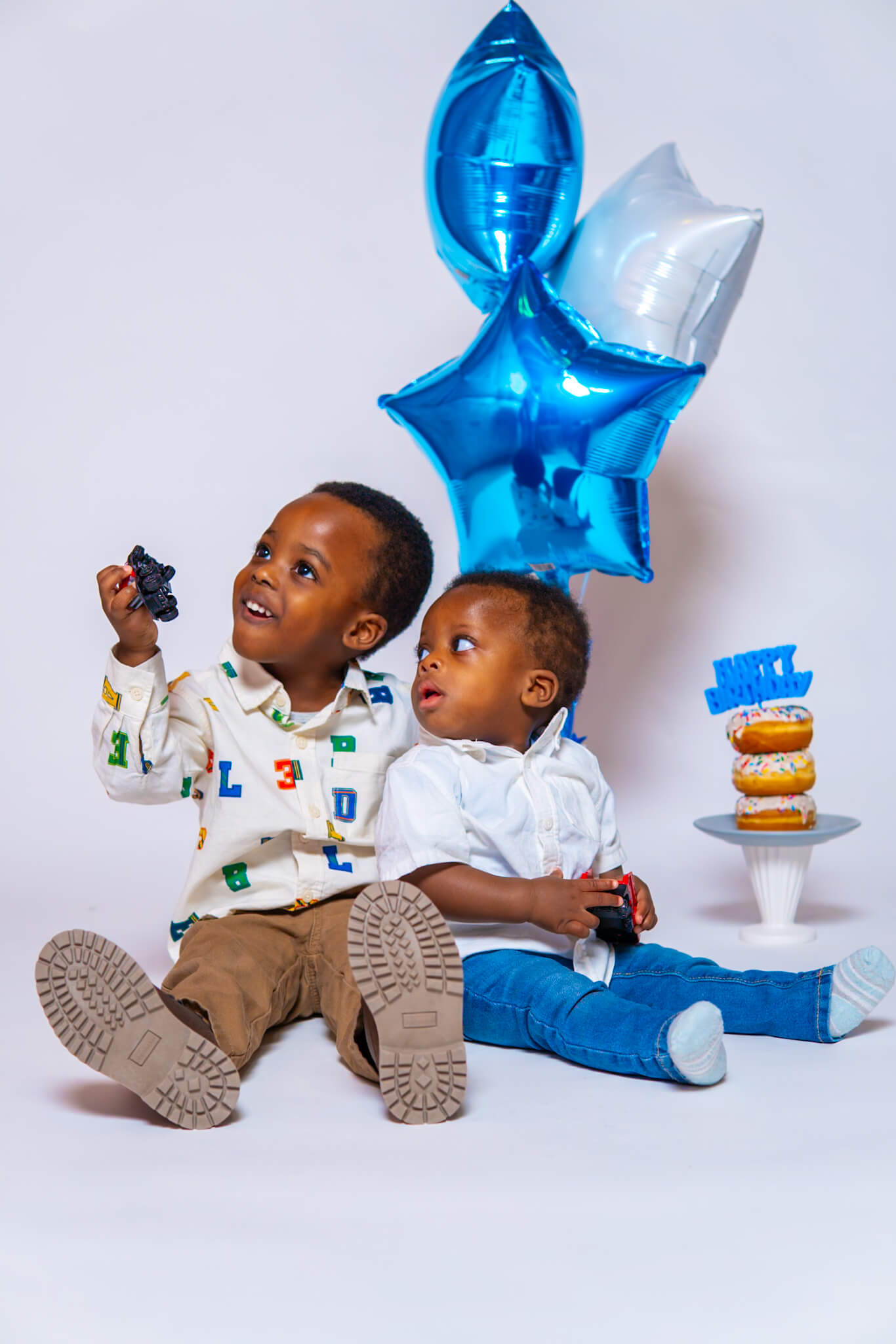 Excited toddler boy laughing while riding a bike in the studio