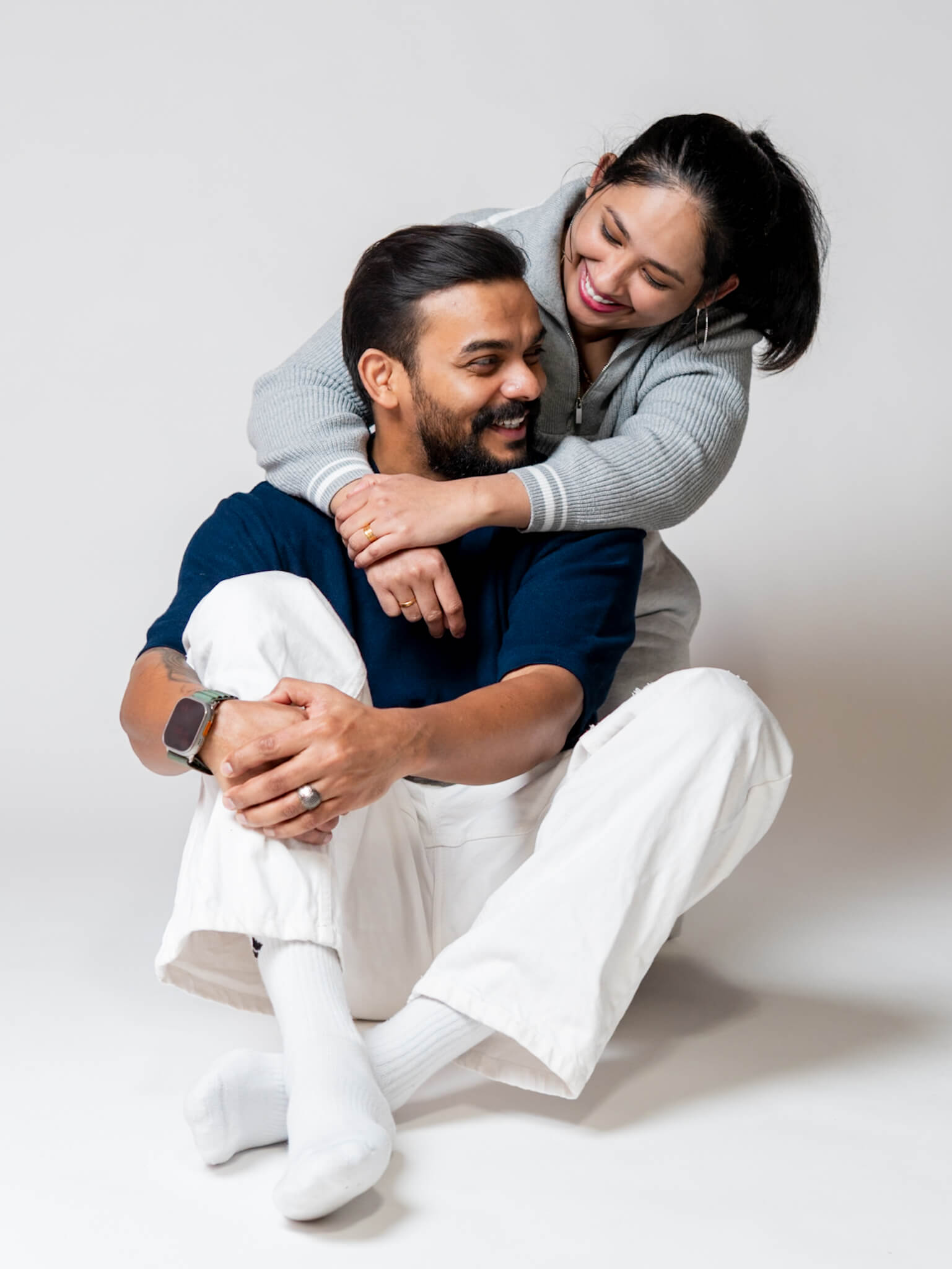 A man and woman laughing and embracing in a Kitchener studio