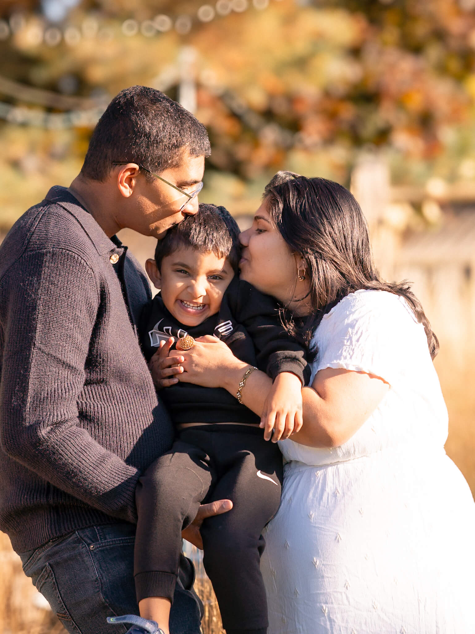 Parents embracing their young son during golden hour in Cambridge ON